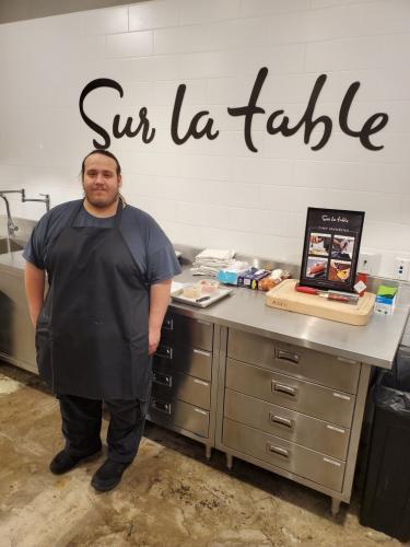 Tyler Cain in front of Sur La Table sign