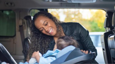 woman strapping baby in carseat