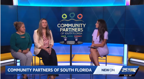 three women sit on a news stage